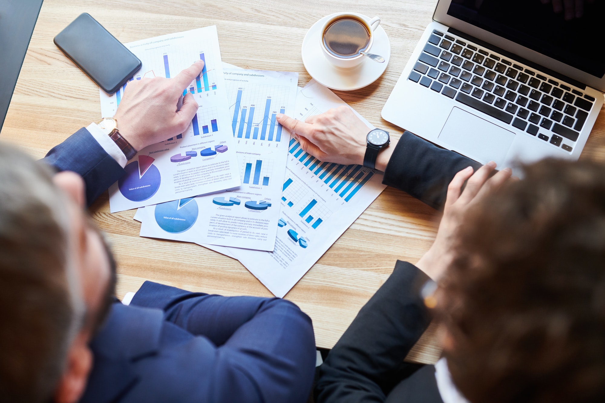 two people sitting Infront of a laptop both are pointing at the graphs