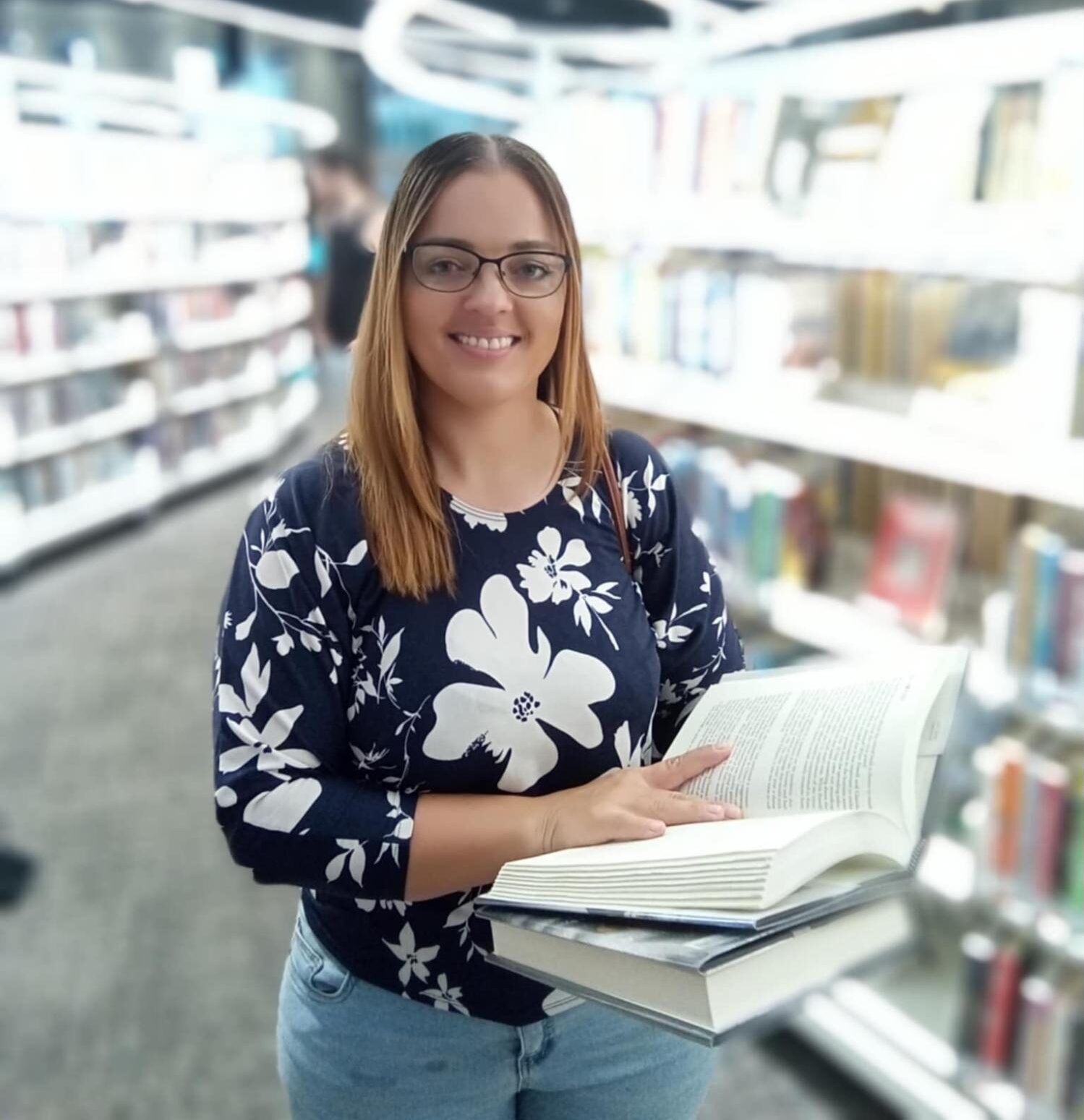 a woman holding a book in a library