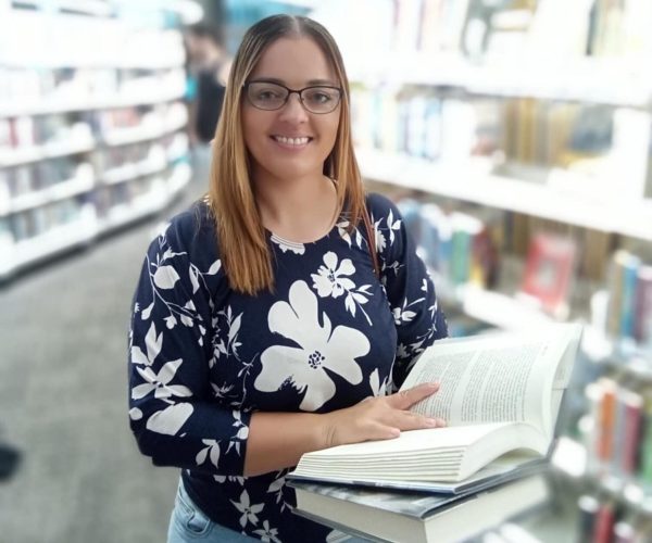 a woman holding a book in a library